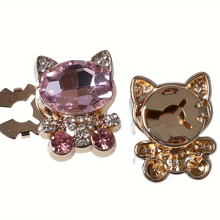 Two cat-shaped brooches with gemstones on a white background