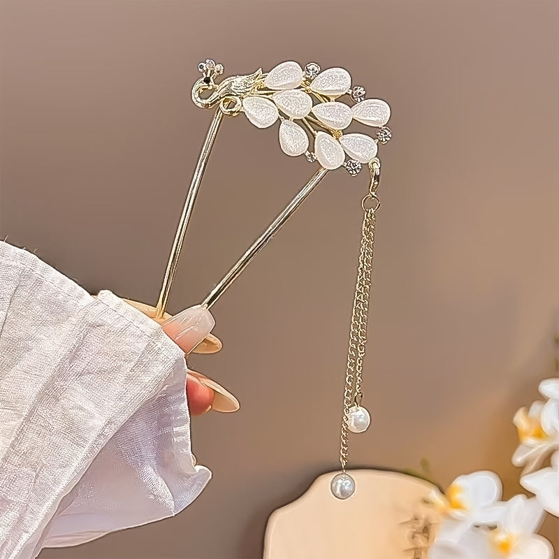 Decorative hairpin with floral design held by a hand against a blurred background