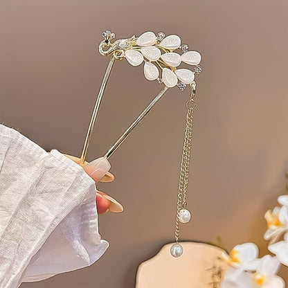 Decorative hairpin with floral design held by a hand against a blurred background