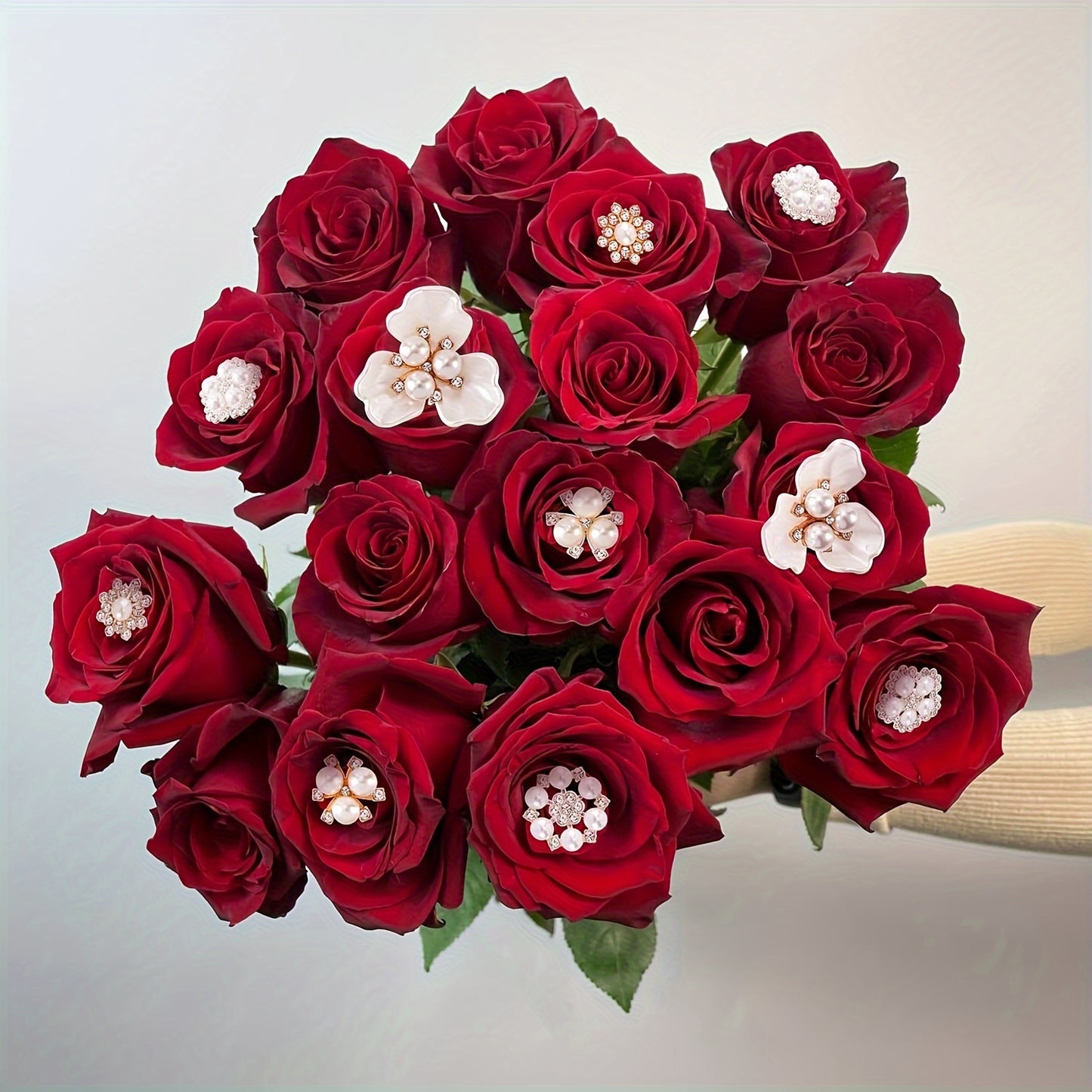 Bouquet of red roses with decorative elements on a light background