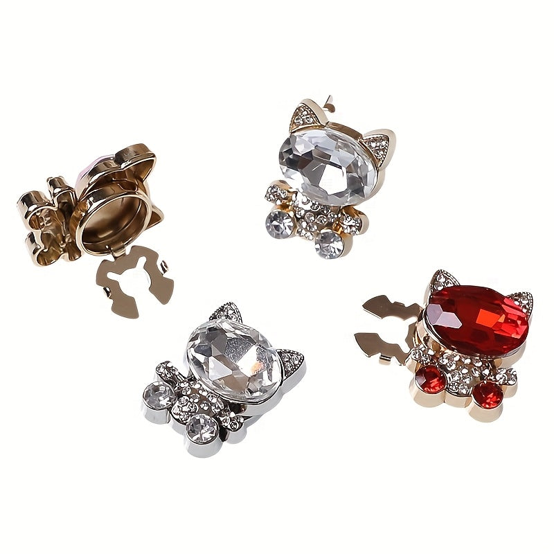 Set of cat-shaped earrings with crystal and red gemstones on a white background