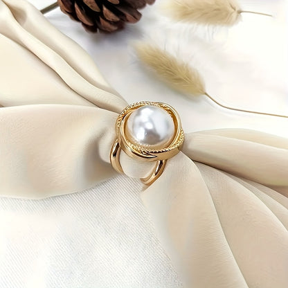 Gold ring with a pearl on a beige fabric background