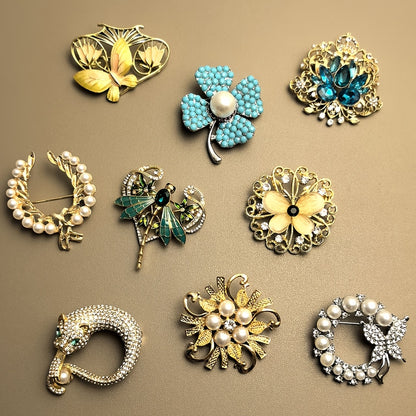 Collection of various jewelry pins on a beige background