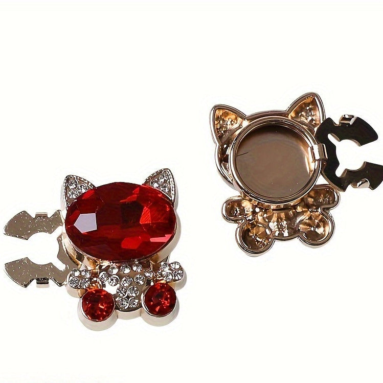 Cat-shaped hair accessories with red gemstones on a white background
