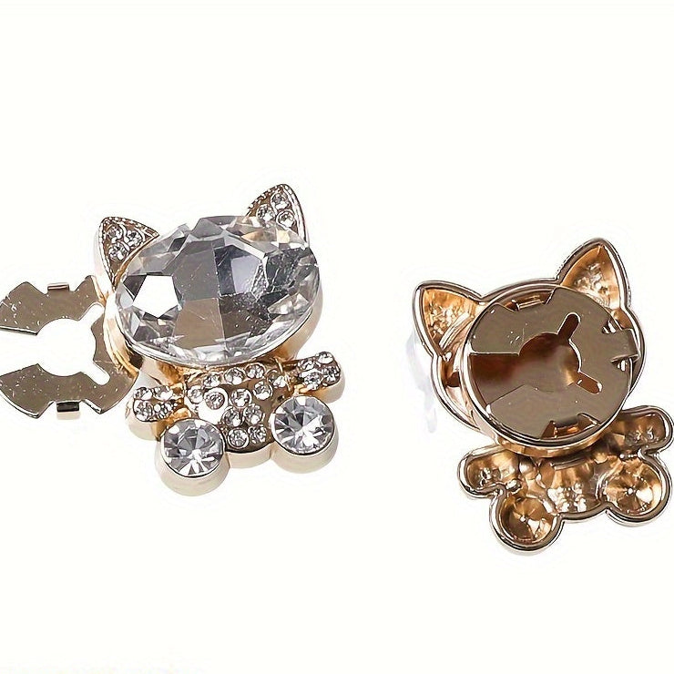 Cat-shaped jewelry with crystal details on a white background
