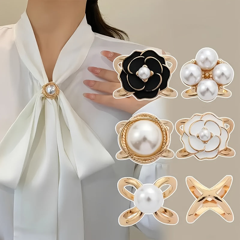 Pearl and gold brooches displayed on a white blouse with a neutral background