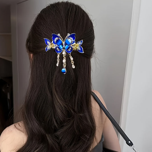 Person with long dark hair wearing a blue butterfly hair accessory.