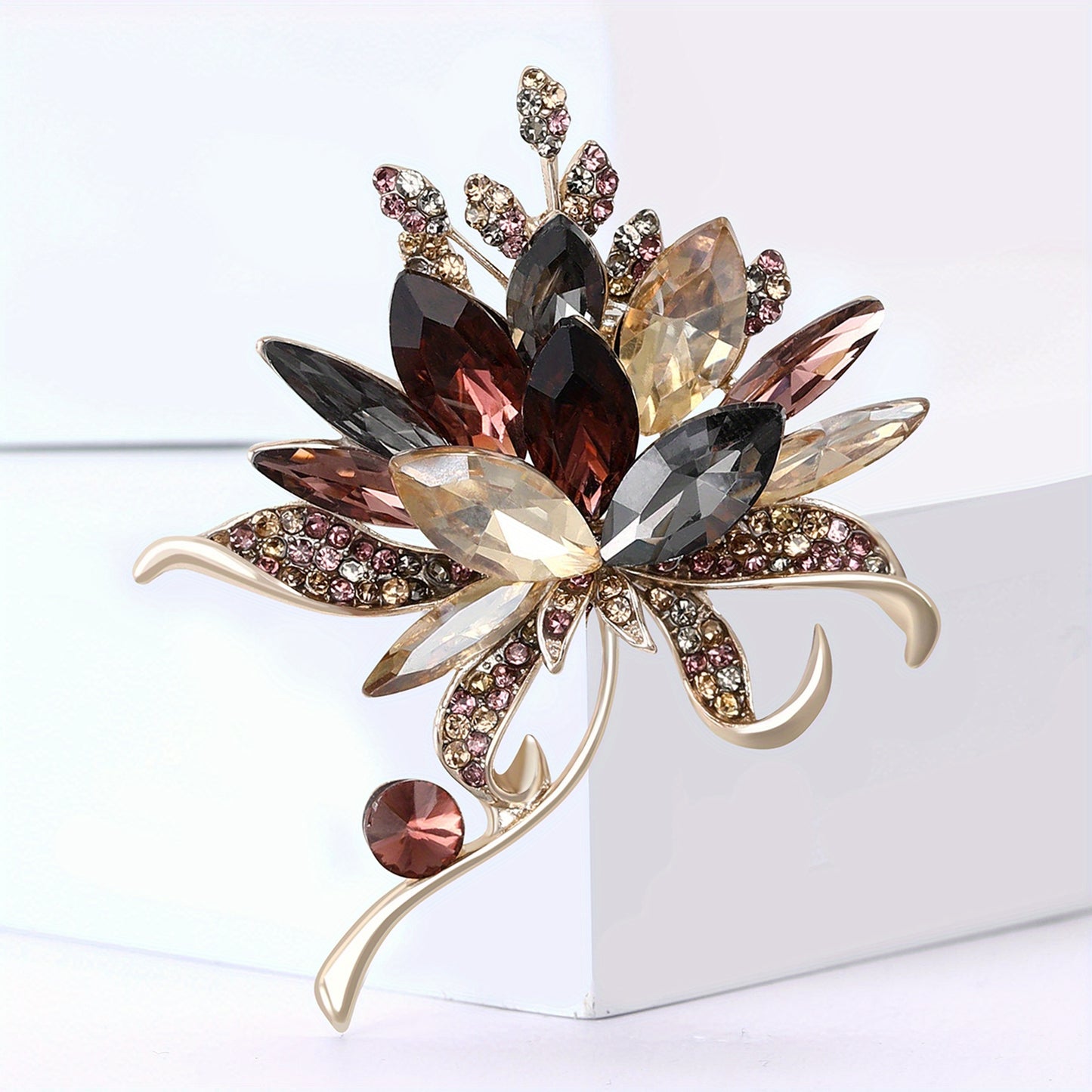 Decorative brooch with multicolored gemstones on a white background