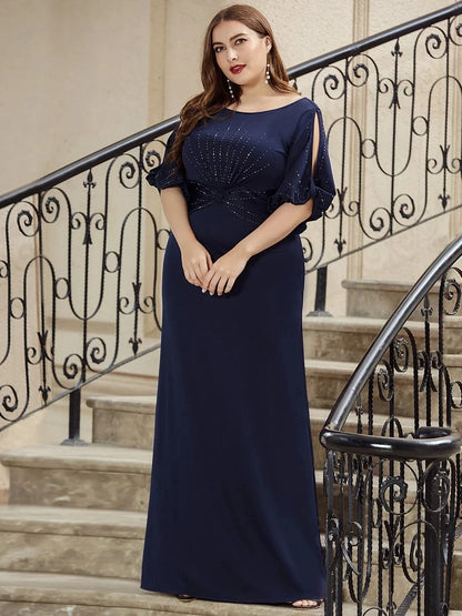 Woman in a navy blue evening gown standing on a staircase with decorative railings.