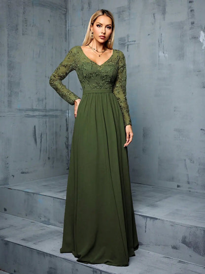 Woman wearing a green dress standing against a gray concrete wall.