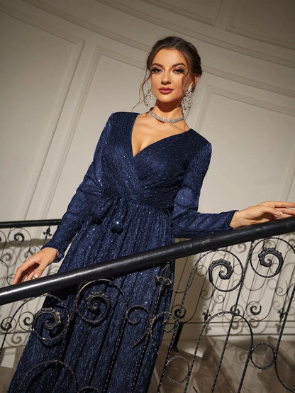 Woman in a blue evening gown standing on a staircase