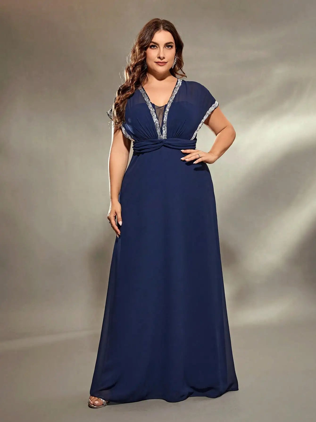Woman wearing a blue evening gown against a neutral background