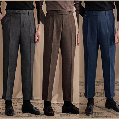 Three pairs of men's dress pants in gray, brown, and blue on a neutral background.
