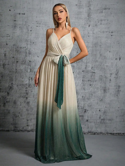 Woman wearing a white and green gradient dress against a gray concrete wall.