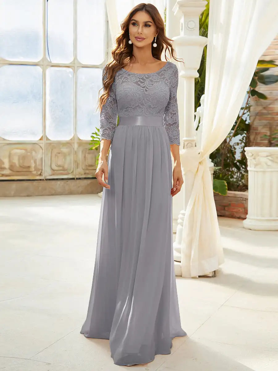 Woman wearing a gray lace dress in an elegant indoor setting