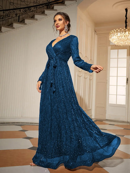 Woman in a blue evening gown standing in an elegant interior setting.