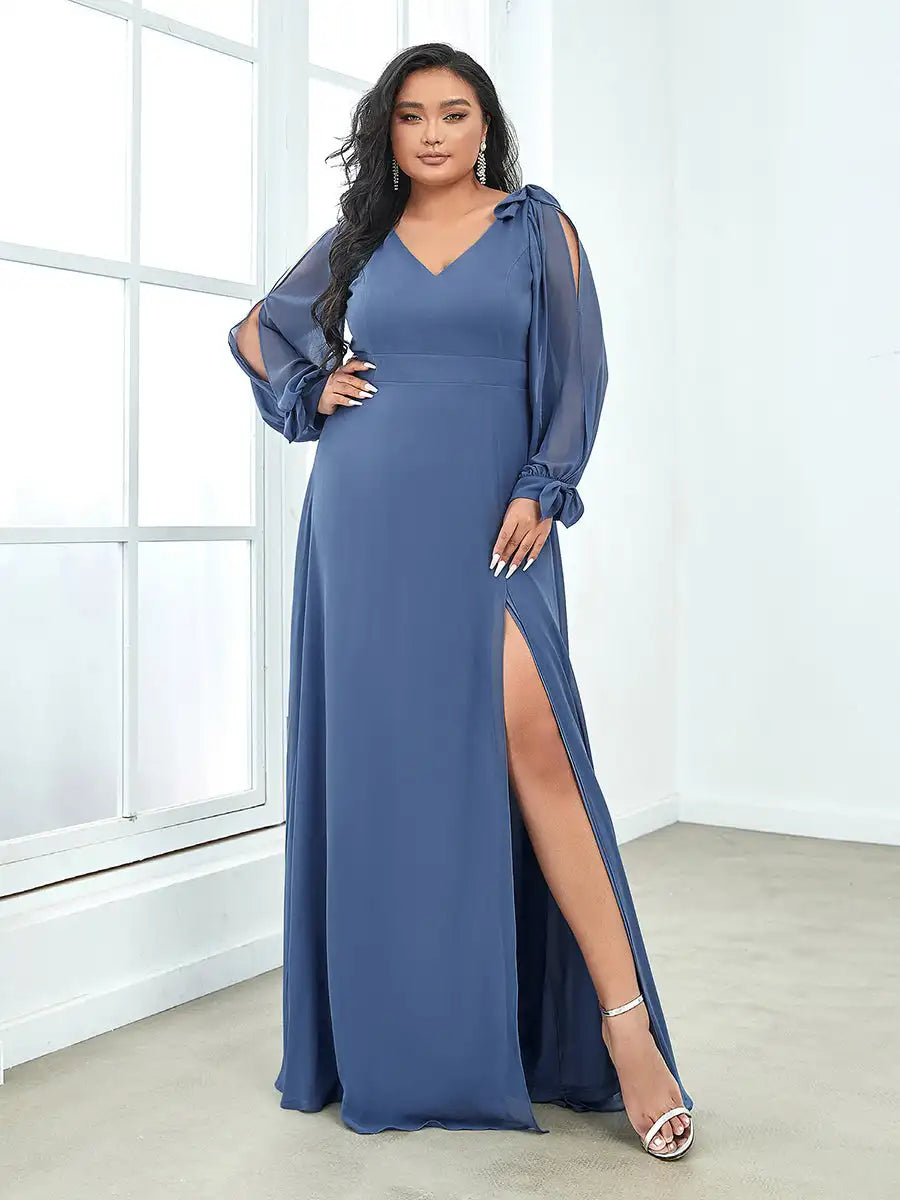 Woman wearing a blue evening gown with a slit in a room with large windows.