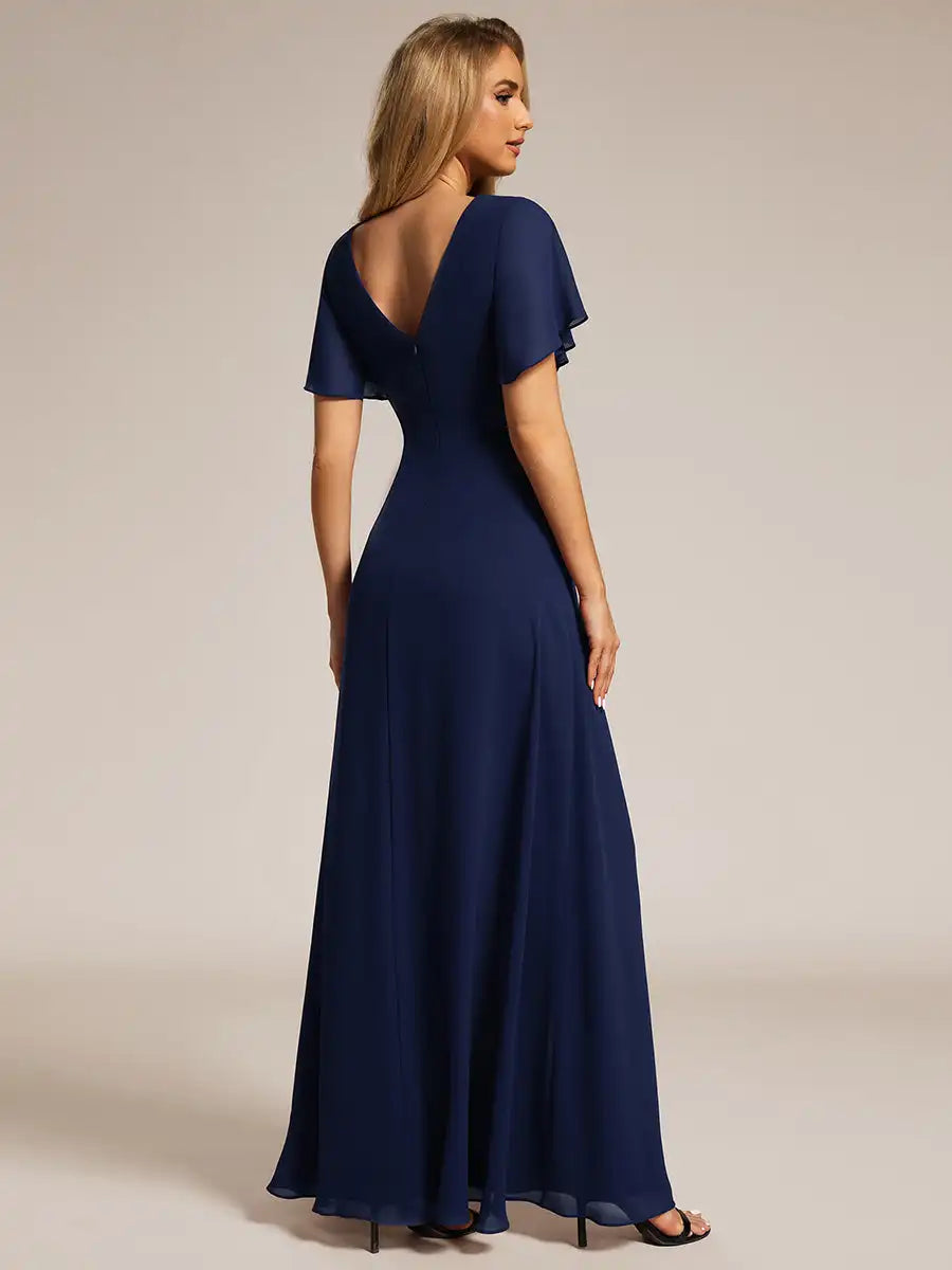 Navy blue evening gown with a deep neckline on a plain background