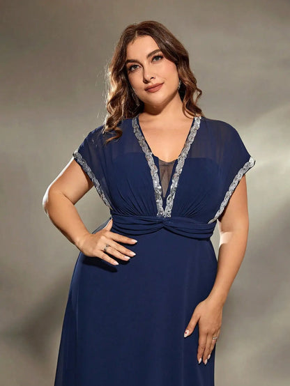Woman wearing a blue dress with silver trim against a neutral background