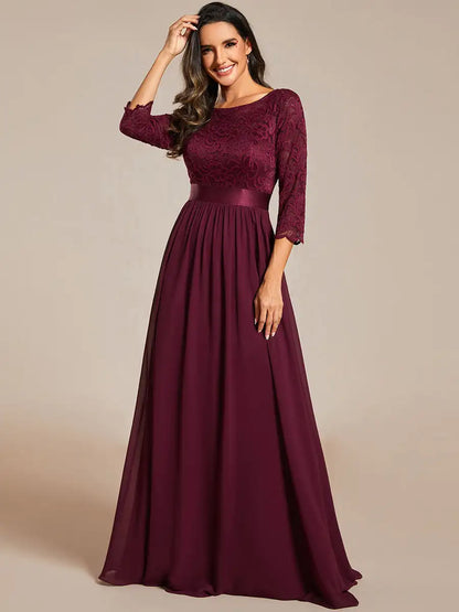 Burgundy evening gown with lace detailing on a beige background