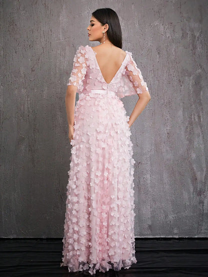 Woman wearing a pink floral evening gown against a gray background
