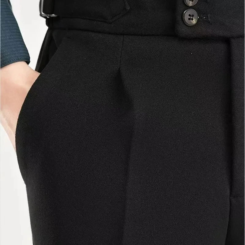 Close-up of black pants with a belt and buttons on a white background