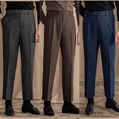 Three pairs of men's dress pants in gray, brown, and blue on a neutral background.