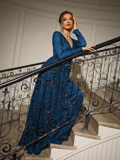 Woman in a blue dress standing on a staircase with decorative railings.