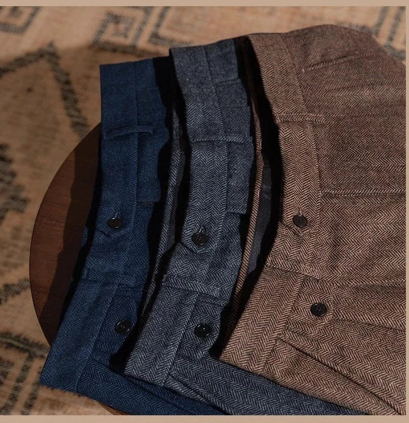 Three pairs of pants in blue and brown on a textured surface