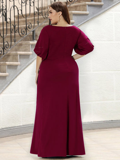 Woman wearing a burgundy dress standing on a staircase.