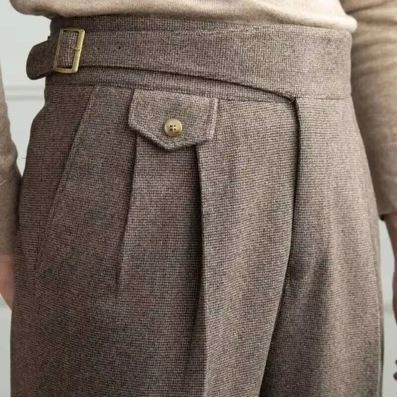 Close-up of brown tweed pants with a button and belt buckle.