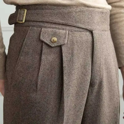 Close-up of brown tweed pants with a button and belt buckle.
