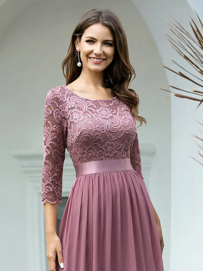 Woman wearing a pink lace dress with a plain background