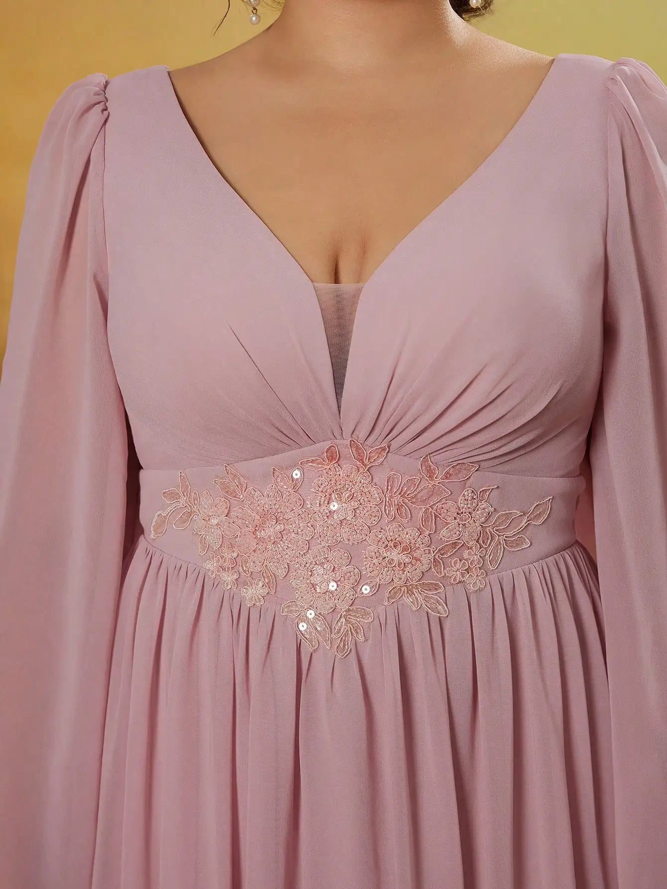 Pink dress with floral embroidery on a yellow background