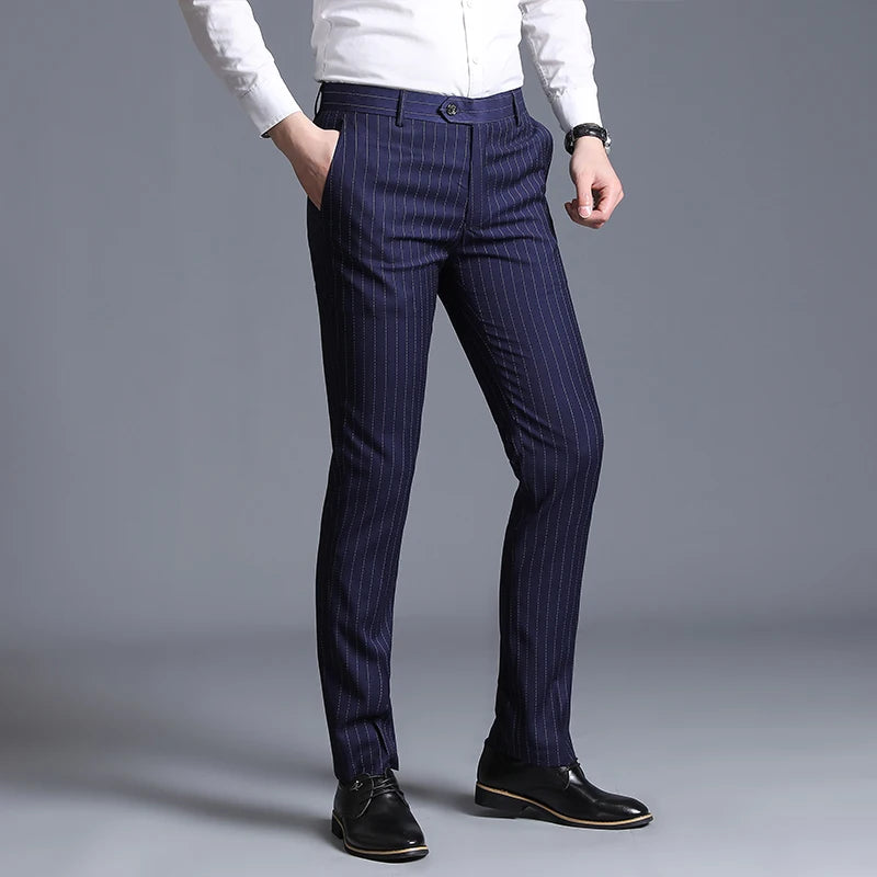 Navy pinstripe pants worn with a white shirt on a gray background