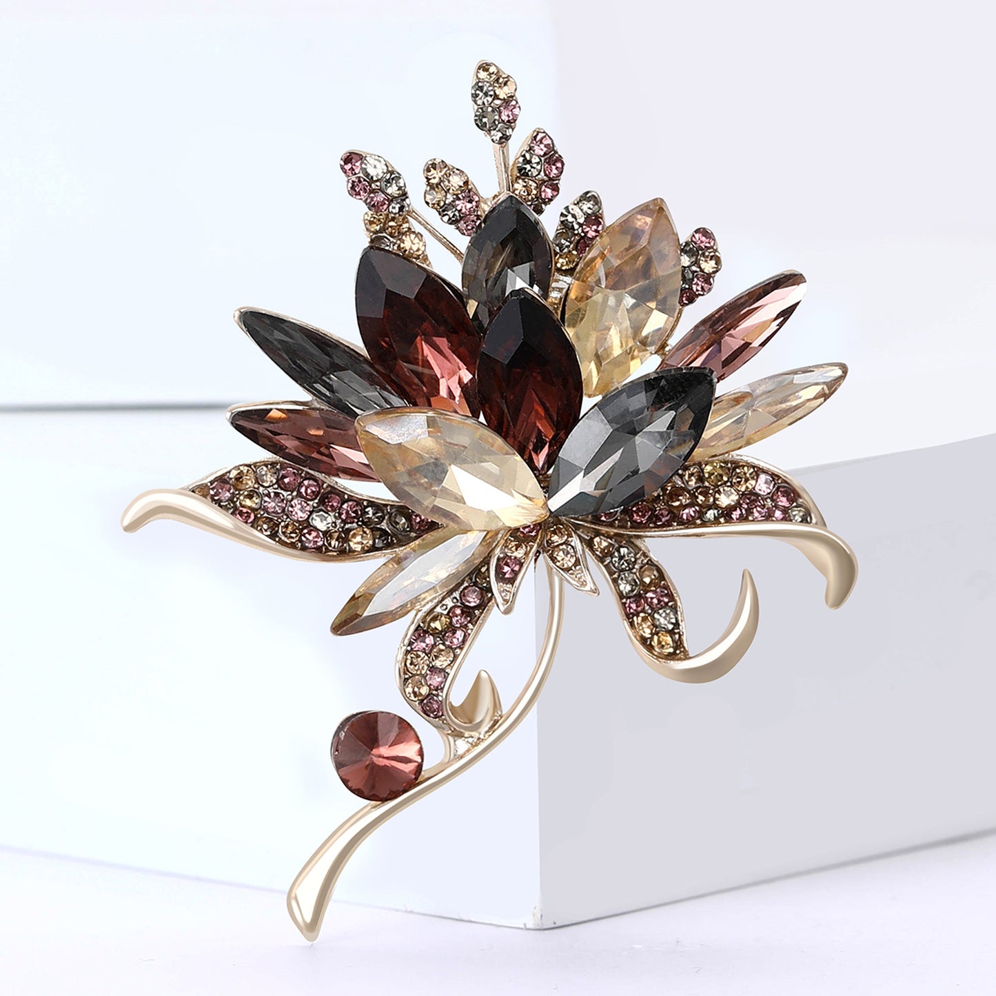 Decorative brooch with multicolored gemstones on a white background