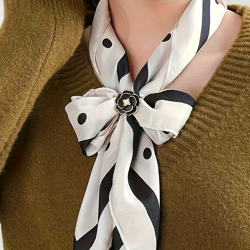 White scarf with black polka dots and stripes tied around a neck against a brown background