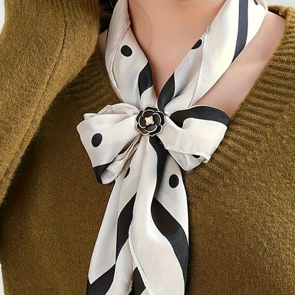White scarf with black polka dots and stripes tied around a neck against a brown background