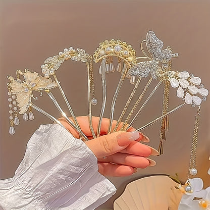 Hand holding decorative hairpins with intricate designs against a neutral background